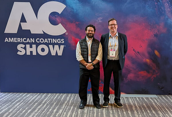 Jonathan und Markus vor dem Logo American Coating Shows